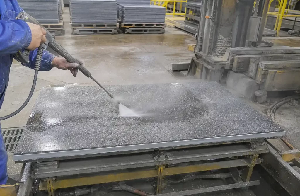 Worker performing simple maintenance cleaning on GMT pallet surface