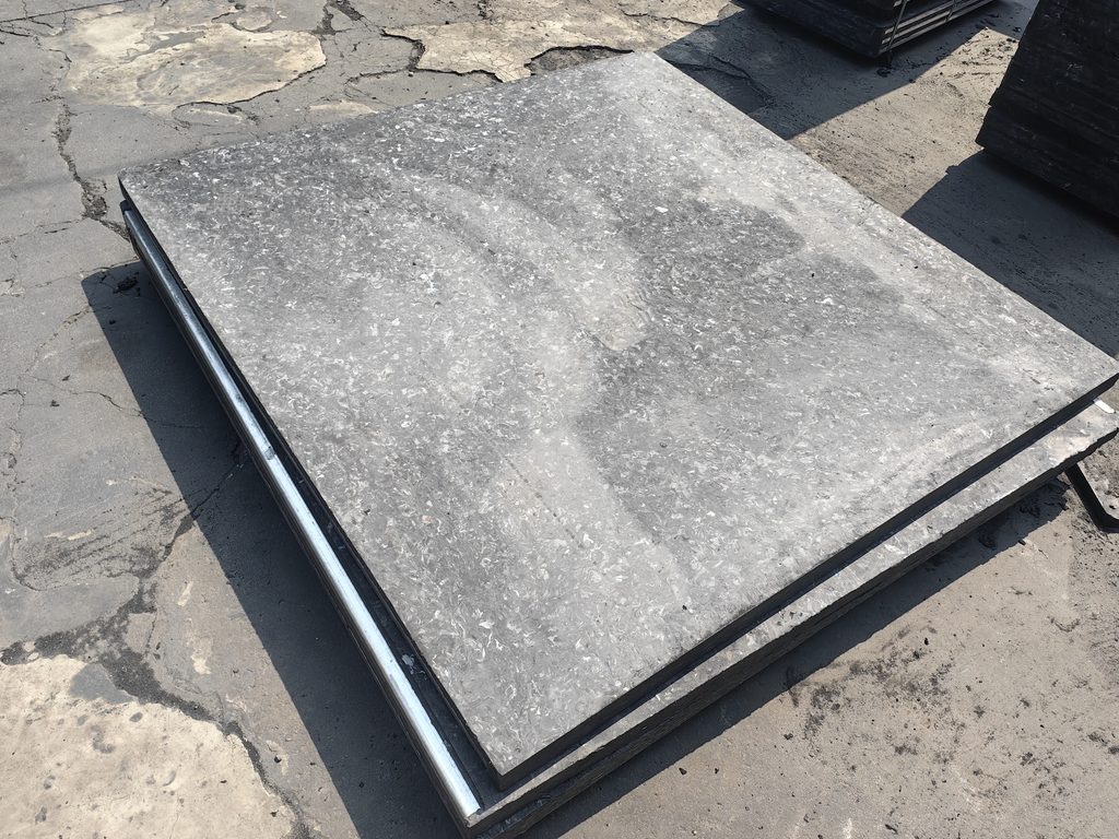 Compression molded glass fiber GMT pallets in industrial manufacturing facility