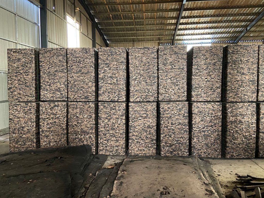 Fresh concrete bricks curing on beveled edge GMT pallets in production facility